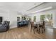 Modern open floor plan connecting kitchen, dining, and living areas with hardwood floors and natural light at 1445 Downwood Pl, Charleston, SC 29412