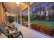 Inviting covered porch with chairs overlooking a spacious backyard with lush greenery and mature trees at 152 Candace Dr, Ridgeville, SC 29472
