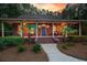 Quaint brick home featuring a welcoming front porch, palm trees, and manicured landscaping at 152 Candace Dr, Ridgeville, SC 29472