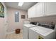 Functional laundry room features white cabinetry, washer, dryer, and tile flooring at 152 Candace Dr, Ridgeville, SC 29472