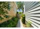 Narrow side yard showcasing a pea gravel path, mature greenery, and the home's exterior at 158 Darlington Ave, Charleston, SC 29403