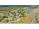 Aerial view showcasing a pond, tennis courts, and charming townhomes amidst beautiful trees at 166 River Breeze Dr, Charleston, SC 29407