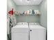 Functional laundry room with washer, dryer, overhead shelving, and ample space for laundry tasks at 166 River Breeze Dr, Charleston, SC 29407