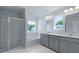This bathroom has dual vanities, a walk-in shower, a garden tub, and large windows at 187 E Pinckney St, Summerville, SC 29485