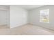 Bright bedroom with plush carpet, two doors, and a window letting in natural light at 191 E Pinckney St, Summerville, SC 29485