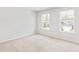 This bedroom features plush carpet, two bright windows, and fresh white walls at 191 E Pinckney St, Summerville, SC 29485