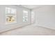 This bedroom features two large, bright windows, plush carpet, and fresh white walls at 191 E Pinckney St, Summerville, SC 29485