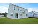 Spacious backyard with lush green grass, a concrete patio, and the home's exterior featuring light green siding at 199 E Pinckney St, Summerville, SC 29485