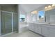 Bright bathroom with a shower, tub, double sink vanity, and a large window providing outdoor views at 199 E Pinckney St, Summerville, SC 29485