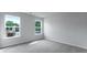 Bedroom with two windows and light grey walls and carpet at 199 E Pinckney St, Summerville, SC 29485