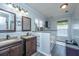 Bathroom showcasing double sinks, wood-look vanities, mirrors, and a bright, airy ambiance at 208 Waterford Ln, Summerville, SC 29483