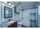 Cozy bathroom with a wood-framed mirror, modern vanity, and a shower with a colorful striped curtain at 208 Waterford Ln, Summerville, SC 29483