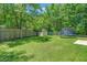 Well-maintained backyard featuring a trampoline, storage shed, privacy fence, and lush green grass at 214 Blackstone Dr, Moncks Corner, SC 29461