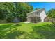 Expansive backyard with a trampoline, fire pit, lush greenery, and a covered patio area for outdoor enjoyment at 214 Blackstone Dr, Moncks Corner, SC 29461