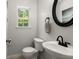 Half bathroom with pedestal sink, round mirror, and natural light from the window at 214 Blackstone Dr, Moncks Corner, SC 29461