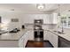 Well-lit kitchen with white cabinets, stainless steel appliances, granite countertops, and stylish dark hardwood flooring at 214 Blackstone Dr, Moncks Corner, SC 29461