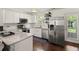 Modern kitchen featuring white cabinets, stainless steel appliances, granite countertops, and dark hardwood flooring at 214 Blackstone Dr, Moncks Corner, SC 29461