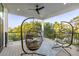 Relaxing covered porch features egg chairs, wood floors, ceiling fan and iron railing overlooking the beautiful greenery at 2213 Rolling Dune Rd, Seabrook Island, SC 29455