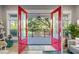 Inviting entryway features vibrant red double doors leading to a spacious porch with a scenic view at 2213 Rolling Dune Rd, Seabrook Island, SC 29455