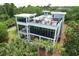 Modern three-story home featuring rooftop terrace and outdoor seating is surrounded by palm trees at 2213 Rolling Dune Rd, Seabrook Island, SC 29455