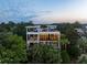 Striking multi-story home surrounded by lush palms, featuring multiple balconies and large windows at 2213 Rolling Dune Rd, Seabrook Island, SC 29455