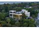 Beautiful multi-story home with multiple balconies and rooftop deck, surrounded by lush greenery at dusk at 2213 Rolling Dune Rd, Seabrook Island, SC 29455