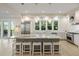 Modern kitchen with stainless steel appliances, island with stools, hardwood floors, and ample natural light at 2213 Rolling Dune Rd, Seabrook Island, SC 29455