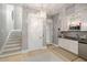 Modern kitchenette equipped with white cabinetry, stainless steel appliances, and convenient access to the staircase at 2213 Rolling Dune Rd, Seabrook Island, SC 29455