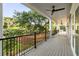 Expansive covered porch with wood floors, ceiling fan, and comfortable seating overlooking lush greenery at 2213 Rolling Dune Rd, Seabrook Island, SC 29455