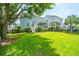 Lush backyard showcasing a well-manicured lawn, mature trees, and a charming patio, ideal for outdoor living at 2234 Mother Of Pearl Dr, Mount Pleasant, SC 29466