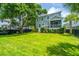 Beautiful backyard with a large, grassy lawn, shaded by mature trees, and complemented by well-maintained landscaping at 2234 Mother Of Pearl Dr, Mount Pleasant, SC 29466