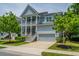 Charming two-story home featuring double porches, a grey garage door, and manicured landscaping at 2234 Mother Of Pearl Dr, Mount Pleasant, SC 29466
