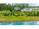 Expansive backyard featuring meticulously landscaped garden and mature trees, bordering a serene pond at 225 Camber Rd, Huger, SC 29450