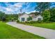 Charming home with manicured lawn, mature trees, and a welcoming driveway; showcasing curb appeal and serene setting at 225 Camber Rd, Huger, SC 29450