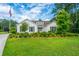Beautiful home featuring a lush green lawn, manicured shrubs, and mature trees, exuding curb appeal at 225 Camber Rd, Huger, SC 29450