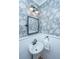 Stylish powder room featuring floral wallpaper, modern lighting, and a pedestal sink, perfect for guests at 225 Camber Rd, Huger, SC 29450