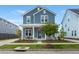 Charming two-story blue home boasts a welcoming front porch and well-manicured lawn at 238 Bird Song Path, Summerville, SC 29485