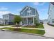 Charming two-story blue home boasts a welcoming front porch and well-manicured lawn at 238 Bird Song Path, Summerville, SC 29485