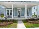 Inviting front porch with seating, columns, and craftsman style door at 238 Bird Song Path, Summerville, SC 29485