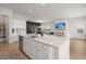 Open-concept kitchen features white cabinets, granite counters, and flows into the living room at 238 Bird Song Path, Summerville, SC 29485