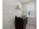 Bright laundry room featuring a front-load washer and dryer with storage shelves above and a patterned rug at 238 Bird Song Path, Summerville, SC 29485