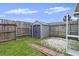 Fenced backyard featuring a storage shed and brick lined landscaping at 242 Swallowtail Ln, Goose Creek, SC 29445