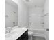 Well-lit bathroom featuring a single sink vanity with black cabinets and a shower-tub combo at 242 Swallowtail Ln, Goose Creek, SC 29445
