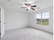 Well-lit bedroom features neutral carpeting, a ceiling fan, and a window overlooking the outdoors at 242 Swallowtail Ln, Goose Creek, SC 29445