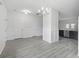 Spacious dining area with a modern chandelier and views of the kitchen, doors to patio, and stairs at 242 Swallowtail Ln, Goose Creek, SC 29445