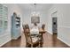 A simple dining area with wood floors, table, cabinet, and chandelier is well-lit by natural light at 2467 Bergeron Way, Mount Pleasant, SC 29466