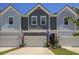 Charming townhome exterior featuring multiple garages, craftsman details, and American and South Carolina flags at 2648 Balena Dr, Mount Pleasant, SC 29466