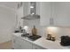 Modern kitchen features gas cooktop, herringbone backsplash, quartz counters and stainless steel range hood at 2648 Balena Dr, Mount Pleasant, SC 29466