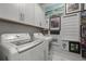 Bright laundry room with white cabinets, modern washer/dryer, and wall decor at 2648 Balena Dr, Mount Pleasant, SC 29466