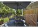 Shaded patio featuring outdoor dining, blue rug, privacy screen, and landscaped backyard at 2648 Balena Dr, Mount Pleasant, SC 29466